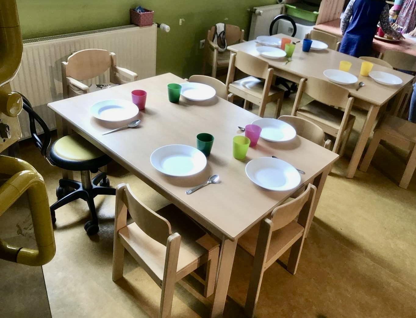 Kinder und Erziehende beim gemeinsamen frisch zubereiteten Mittagessen